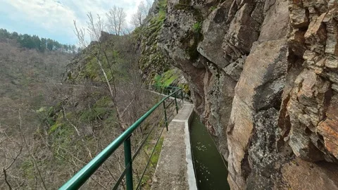 Rugged cliff faces frame a narrow canal path. Vucjanka Canyon, Serbia Vidéo 332171319