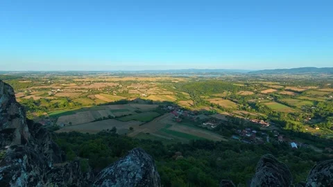 Rugged cliff overlooks vast rolling hills and golden fields. Boracki krs Serbia 動画素材 345005165