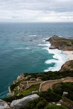 Rugged cliffs and ocean waves at Cape Point in South Africa Stock Photos