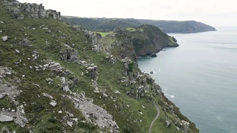 Rugged cliffs coastline perspective skyline, aerial descent to coastal path Vidéo 276494182