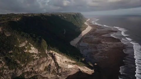 Rugged cliffs of dark, jagged rocks, of green vegetation. Stock Footage 297846082