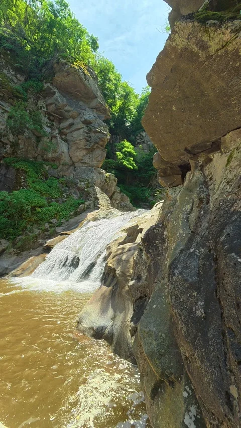 Rugged cliffs frame a cascading waterfall. Vucjanka Canyon, Serbia. Vertical Stock Footage 341131079