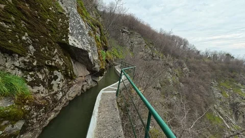 Rugged cliffs frame a serene, narrow canal. Vucjanka Canyon, Serbia Vidéo 332170702