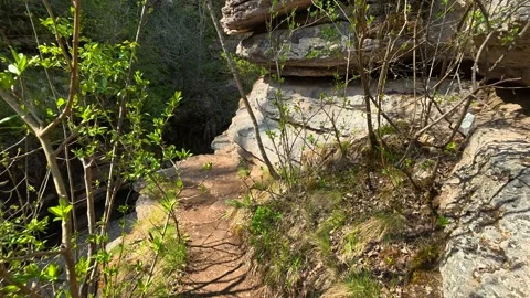 Rugged cliffs line a narrow, sunlit trail. Rosomac Canyon, Serbia Stock Footage 335535767