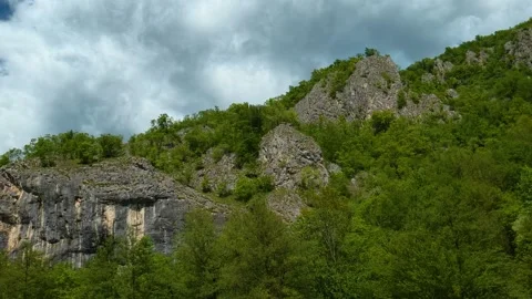 Rugged cliffs rise amid dense green foliage. Gradac River, Serbia Stock Footage 335074253