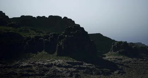 Rugged cliffs stand majestically against a hazy sky at coastal location 스톡 일러스트