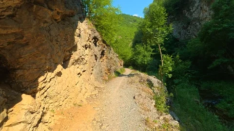 Rugged cliffside frames a narrow gravel path. Gradasnica River Canyon, Serbia Vídeo Stock 341962469