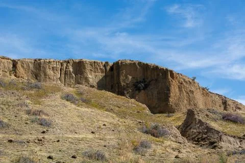 Rugged Cliffside Under Blue Sky Foto stock