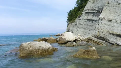 A rugged coast with towering cliffs, jagged rocks, and a serene ocean. Stock Footage 259074685