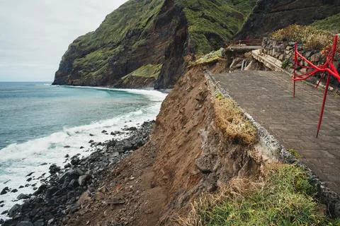 Rugged coastal path on cliff edge next to turbulent ocean surf under overca.. Stock-Fotos