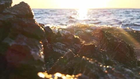 Rugged coastal rocks framing a glowing sunset over the ocean Stock Footage 337418605