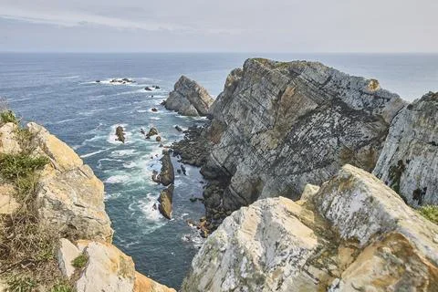 Rugged coastline creating dramatic landscape by ocean Fotos de archivo