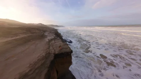Rugged coastline with steep cliffs and white-capped waves at dawn Stock Footage 344677609