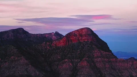 Rugged desert peaks under purple sunset clouds during dusk in a cinematic Stock Footage 345482626