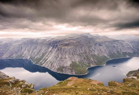 Rugged dramatic mountain landscape in norway cloudy dramatic day with calm lake Stock Photos