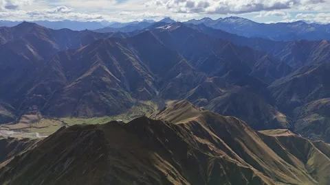 Rugged green mountain range flyover, river in valley far below cloud 库存影片 333031559
