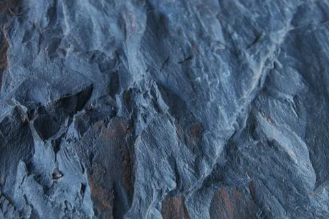 Rugged grey rock texture with subtle brown mineral patches and diagonal ridge Stock Photos