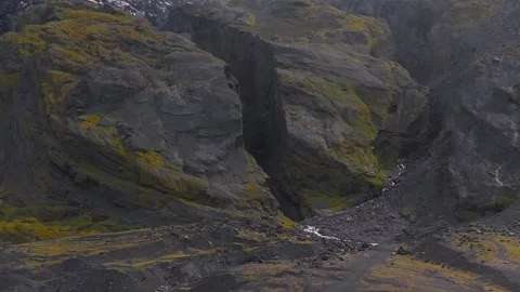 Rugged Icelandic Cliffs with Moss, Stream, and Glacial Elements Stock Footage 313551453