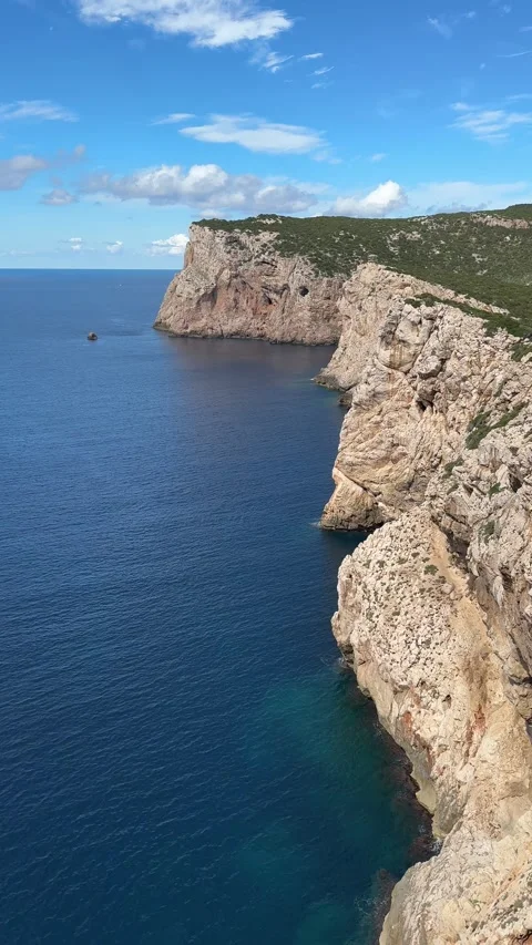 Rugged limestone cliffs of the Gulf of Orosei dropping into the turquoise Tyrrhe Stock Footage 333795290
