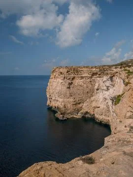 Rugged Maltese cliffs  with dramatic rock formations and the deep blue sea Stock Photos