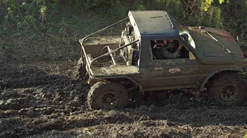 Rugged, modified 4x4 truck racing through deep mud Stock Footage 345495665