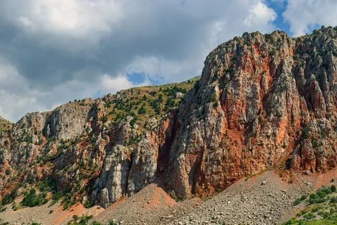 Rugged mountain cliffs with mixed red and gray rock textures Stock Photos