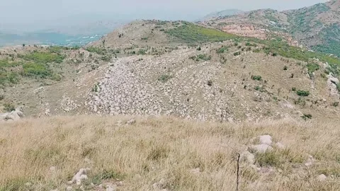 Rugged Mountain Peaks Overlooking Dry Grassy Valley Under Blue Sky Stock Footage 333611861