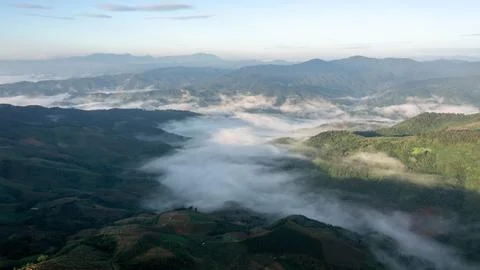 Rugged Mountain Range Peaks Emerging From Thick Morning Mist At Dawn Landsc.. Stockfoto's