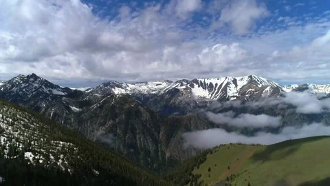 Rugged mountain range with snowy slopes and pine forest Stock Footage 340962793