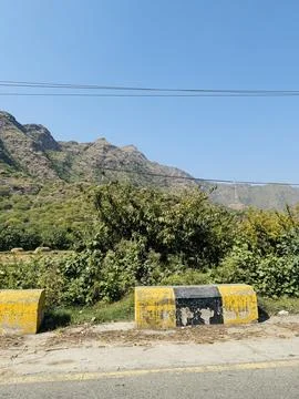 Rugged Mountain View Behind a Yellow Road Barrier Stock Photos