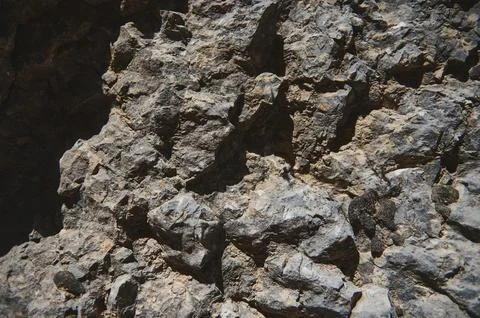 Rugged Natural Stone Surface Capturing Texture and Detail on a Bright Day Stock Photos