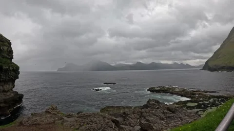 Rugged ocean cliffs and flying sea birds under overcast sky, Faroe Islands Stock Footage 340026883