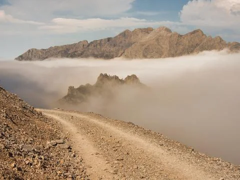 Rugged ridge above cloud inversion panorama - Elevated hiking trail on a ro.. Stock Photos