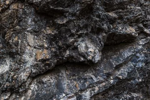 Rugged Rock Face Texture with Dark Weathered Stone Layers Fotos de archivo