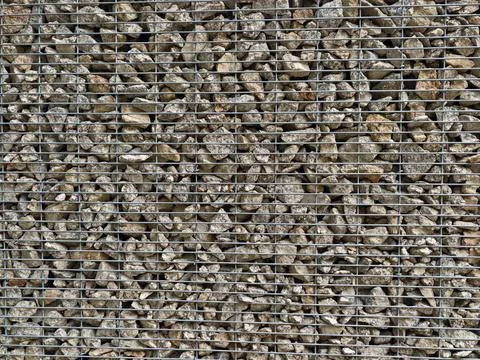 Rugged rock-filled wire cage wall Stock Photos
