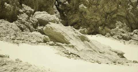 Rugged rock formation in a desolate sandy landscape under a clear sky Illustrazione stock