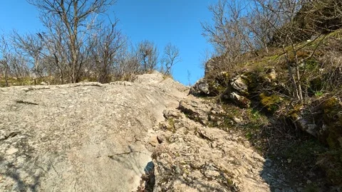 Rugged rock path winds upward under clear blue sky. Mount Ozren 스톡 동영상 330958991