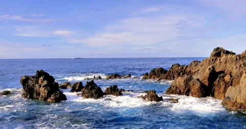 Rugged rocks, crashing waves, and endless blue Stock Footage 313842389