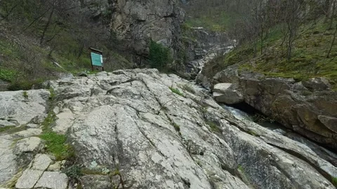 Rugged rocks slope down to a narrow stream. Vucjanka Canyon, Serbia Stock Footage 332147926