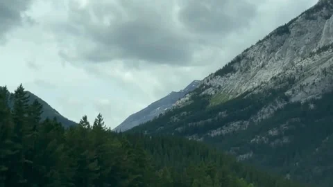 Rugged rocky mountain peaks towering over evergreen forest landscape view. Stock Footage 344244877