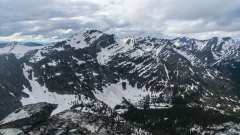 Rugged rocky mountain range in spring with snow and clouds Stock Footage 167113397