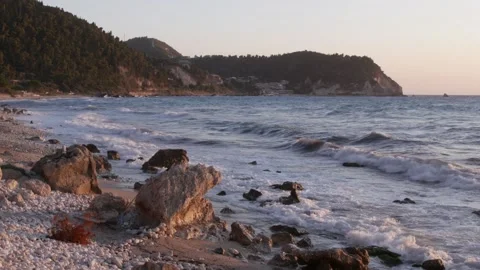 Rugged Seaside Rocks Surrounded by Foamy Ocean Waves at Sunset Stock Footage 340036081