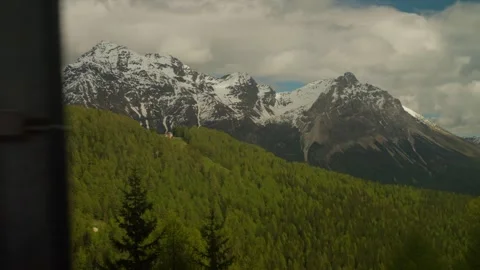 Rugged snow dusted alpine mountain peaks and dense green conifer forest Stock Footage 331112710