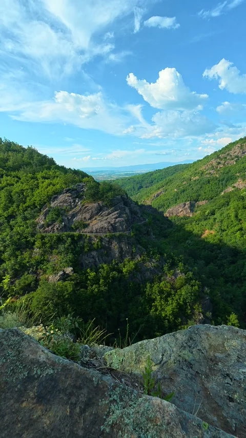 Rugged stone overlooks deep green valley. Sokolica rock, Serbia. Vertical Stock Footage 341131991