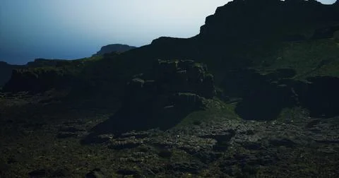 Rugged terrain illuminated by soft sunlight over rocky landscape at dusk Ilustração Stock