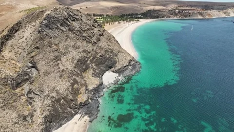 Rugged towering cliffs and coves above a calm blue bay Stock Footage 321790597