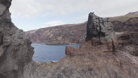 Rugged volcanic coastline revealing dramatic geological formations, carved by 스톡 동영상 308400021