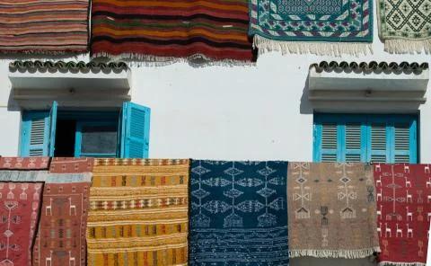 Rugs on whitewashed building 스톡 사진