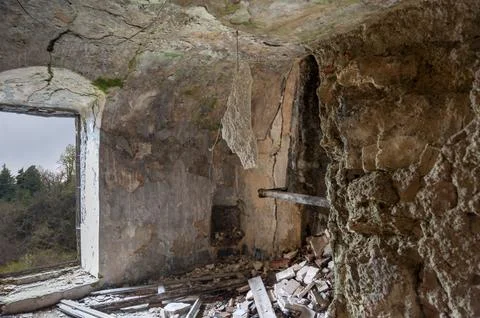 Ruined interior with open window and vegetation outside Stock Photos