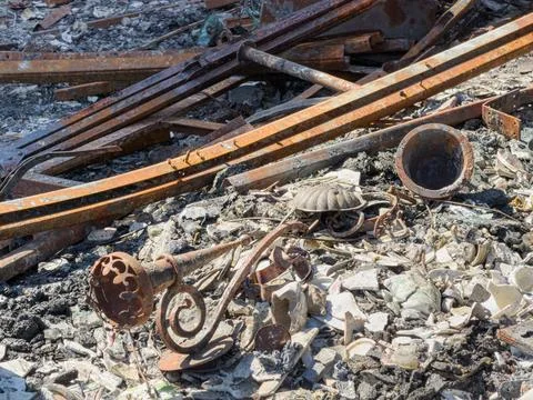 Ruins of building after fire damage, charred ground with rusted metal fragmen Stock Photos